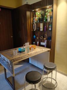 a kitchen with a counter and two stools at Staycation Couple friendly House in Thane