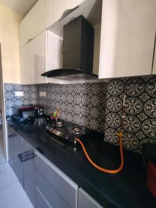 a kitchen with black and white tiles on the wall at Staycation Couple friendly House in Thane