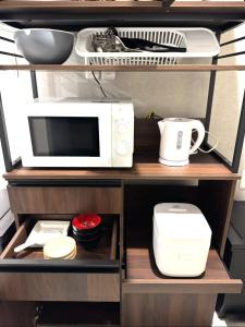 a microwave and other kitchen items on a shelf at Room One in Aomori +13 photos
