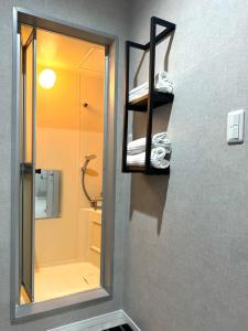 a bathroom with a mirror and a sink and a shower at Room One in Aomori