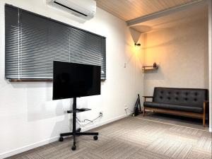 a living room with a flat screen tv and a couch at Room One in Aomori
