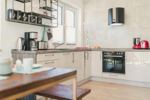 a kitchen with white appliances and a wooden table at Zum Koi Fischer in Fuhlendorf