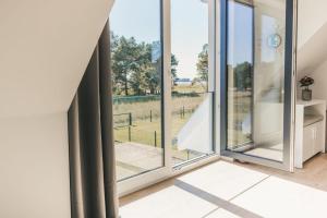 a room with large windows with a view of a field at Zum Koi Fischer in Fuhlendorf