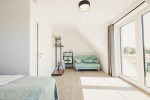 a bedroom with a blue couch and a large window at Zum Koi Fischer in Fuhlendorf +12 photos