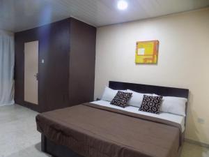 Un dormitorio con una cama grande con almohadas. en Posh Apartments and Hotel, en Ikeja