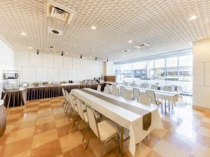 a dining room with a long table and chairs at Yatsushiro Grand Hotel in Yatsushiro