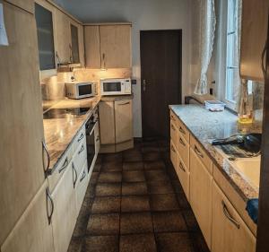 a kitchen with wooden cabinets and a counter top at Pension Highway - Osnabrück Klarastr 11 in Osnabrück