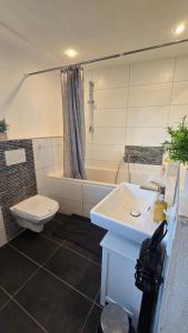 a bathroom with a sink and a toilet and a tub at Denkmal Rhens in Rhens