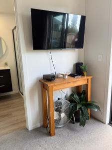 a room with a table with a television on a wall at Cozy Pakura Pad in Te Awamutu
