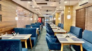 a row of tables and blue chairs in a restaurant at Ananya Comfortss in Hospet