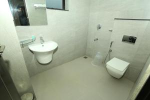 a white bathroom with a toilet and a sink at CeeCee Grand in Vagamon +90 photos