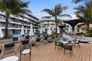 an outdoor patio with chairs and tables and umbrellas at Sunshine Beach Layan by Beringela in Layan Beach