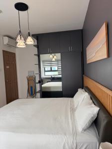 a bedroom with a white bed with black cabinets at Căn Hộ Biên Hoà in Bien Hoa +3 photos