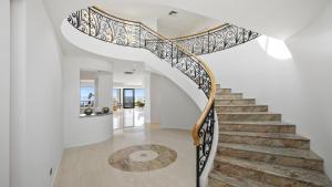 a spiral staircase in a home with white walls at 'Aloha Beach Retreat' by HolidayCo in Norah