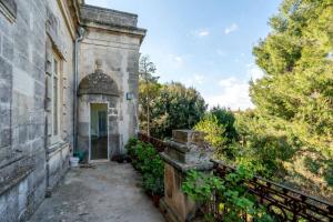 an old stone building with a fence and trees at Palazzo Donna Elisabetta in Manduria