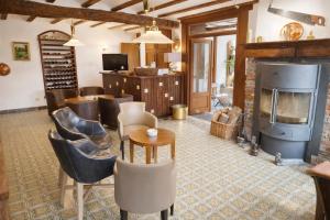 a living room with a fireplace and a table and chairs at Hôtel La Ferme de Sy in Ferrières