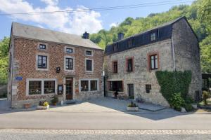 two old brick buildings sitting next to each other at Hôtel La Ferme de Sy in Ferrières