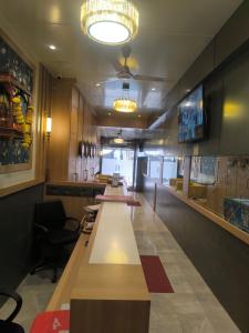 a restaurant with a row of tables and chairs at Hotel Signature in Thane