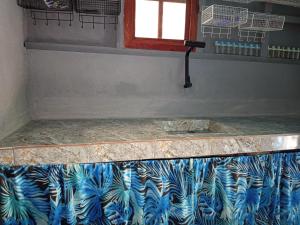 a bathroom with a counter with a blue and white pattern at Sarah House Rental in Clarin