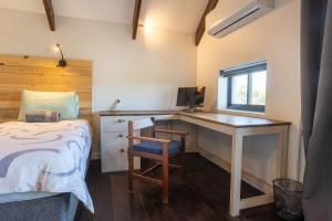 a bedroom with a bed and a desk with a computer at Modern Coastal Retreat - Private Hot Tub & Sauna in Hermanus +81 photos
