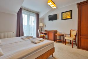 a hotel room with a bed and a desk and a chair at Eden in Rydzyna