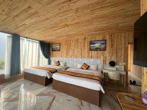 two beds in a room with wooden walls at Sapa May Ecolodge in Sapa +19 photos