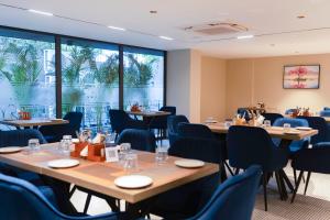 a conference room with tables and chairs and windows at Grand Continent Hotel, Near Sector 44, Gurugram in Gurgaon