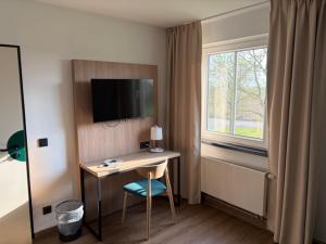 a room with a desk with a computer and a window at ARC Hotel in Halle an der Saale