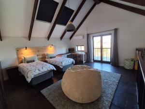a bedroom with two beds and a chair and a table at Modern Coastal Retreat - Private Hot Tub & Sauna in Hermanus