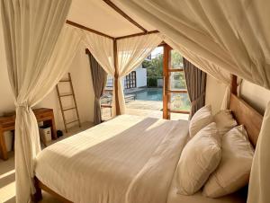 a bedroom with a white bed with a canopy at Villa Light - Amed Bali in Amed +172 photos