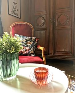 a table with a vase of flowers and a chair at Villa Colombier in Pontgibaud