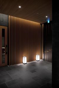 two lights in front of a wall with vertical lines at Hotel Yaenomidori Tokyo in Tokyo