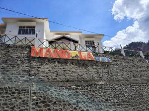 a building with a sign on top of a wall at Mandola Stays in Chamoli