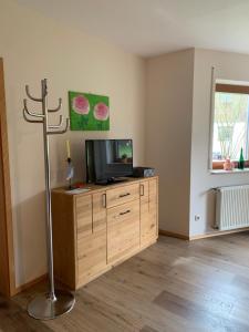 a living room with a tv on a wooden dresser at Ferienwohnung Wehner in Seiferts