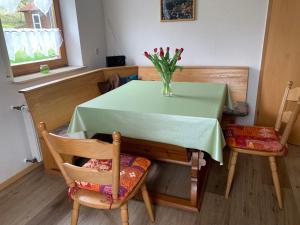 a table with a vase of flowers on top of it at Ferienwohnung Wehner in Seiferts