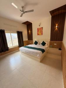 a bedroom with a bed and a ceiling fan at Mandola Stays in Chamoli +7 photos