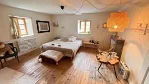 a bedroom with a bed and a table and a chair at Villa Colombier in Pontgibaud