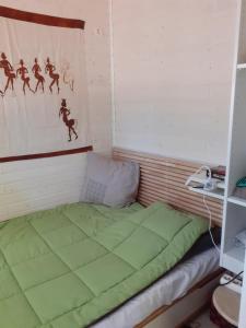 a small room with a green bed in it at Chalet dans le camping l'Orée des Landes à Onesse et Laharie in Onesse-et-Laharie
