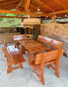 a wooden table and chairs with a stone fireplace at Chalupa ALMA in Žacléř