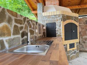 a kitchen with a stone stove and a sink at Chalupa ALMA in Žacléř