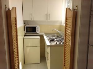 une petite cuisine avec une cuisinière et un micro-ondes dans l'établissement Sunny Apartment Narvarte, à Mexico