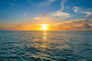 a sunset over the ocean with the sun setting at Stylish Angler's Retreat, Poolside & Ocean Access #16 in Marathon