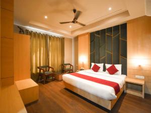 a bedroom with a large bed with red pillows at Lemonade Hotel Alwar in Alwar +15 photos