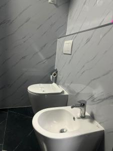 a bathroom with a white sink and a toilet at Iceland Apartment in Tirana +1 photo