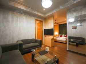 a living room with a couch and a television at Lemonade Hotel Alwar in Alwar