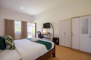 a bedroom with a bed with a desk and a chair at Cove Dahayu Sanctuary in Sanur