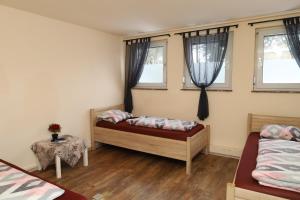 a bedroom with two beds and two windows at Pension Highway - Bielefeld Senner Hellweg 227 in Bielefeld