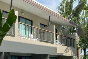 a building with a balcony with palm trees at XAYA Pool Access Resort - Phuket in Phuket