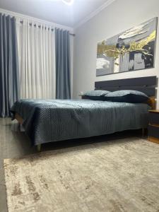 a bedroom with a large bed with blue pillows at Iceland Apartment in Tirana