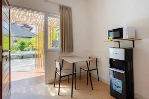 a small kitchen with a table and a microwave at Cove Dahayu Sanctuary in Sanur